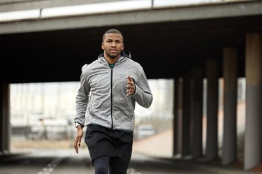 Man doing a beginner running workout outside near a bridge