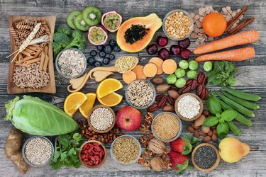 High dietary fiber health food concept with fruit, vegetables, whole wheat pasta, legumes, cereals, nuts and seeds with foods high in omega 3, antioxidants, anthocyanins, smart carbs and vitamins
