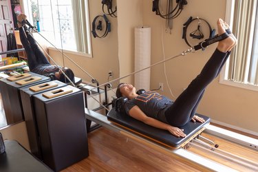 Kristina stretches on her Pilates Reformer.
