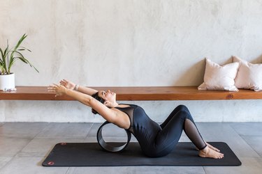 woman doing Spine Release with a yoga wheel