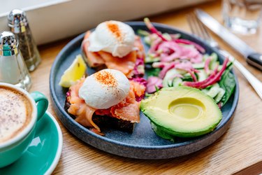poached eggs with salmon and avocado on a blue plate