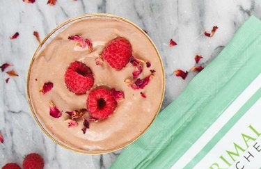 Top view of a keto cacao smoothie with chocolate and raspberries