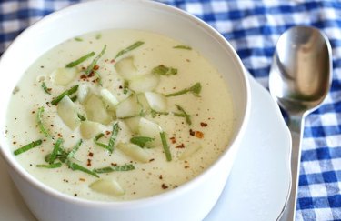 A bowl of white gazpacho with cucumber and avocado