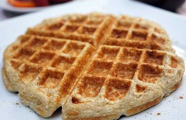 Cinnamon roll waffle on white plate.