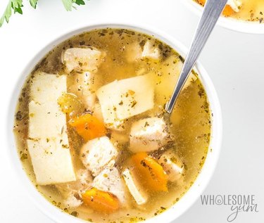 Bowl of chicken and dumplings with carrots.