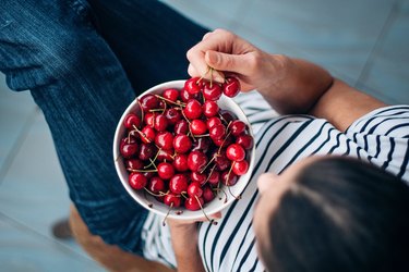 Woman eating cherries as part of an Alkaline Diet