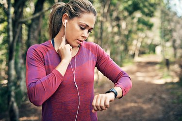 a woman measuring her heart rate while exercising outside