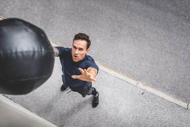 年轻的白人男性运动员做墙球加入健身实心球墙在锻炼