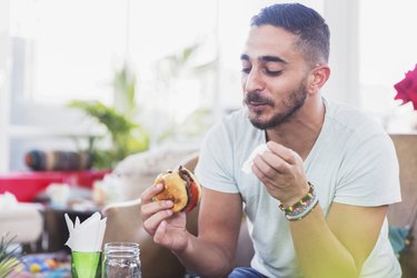 man eating burger off the Whatabuger menu