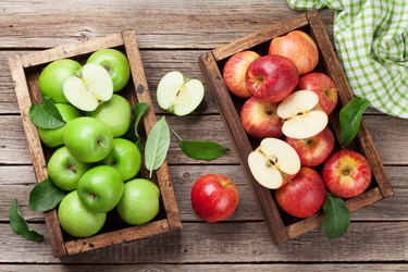 Green and red apples in wooden box