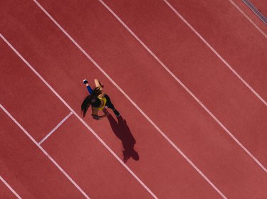 女性跑步听音乐和运动轨道上运行