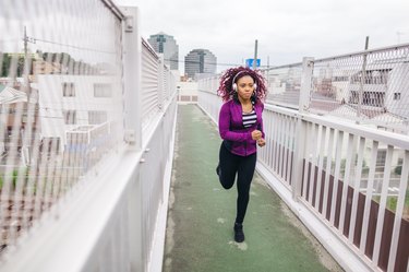 Women running in city on cloudy bad weather day