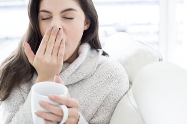 Woman with mug, yawning