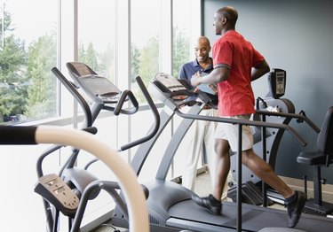 Personal trainer coaching man on treadmill during a winter run
