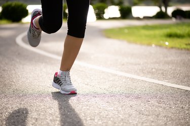 特写女子在路边跑过来。步、跑及户外运动活动概念。