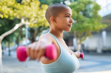 Woman using small weights to do shoulder exercises