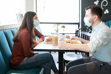 photo of Couple wearing Face Masks and eating at a restaurant