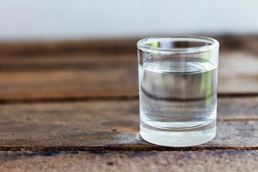 特写的水在饮用玻璃杯木桌上