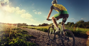 Cyclist riding a bike to the sunset on the ofroad