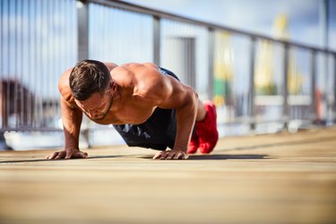 Portrait of a athletic man doing push-ups outside