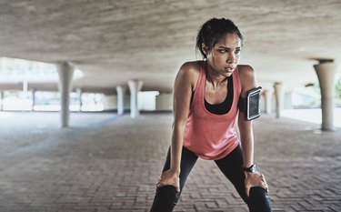 A sweaty woman taking a break from her run outdoors