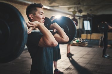 Man lifting a loaded barbell to find his one-rep max in the gym