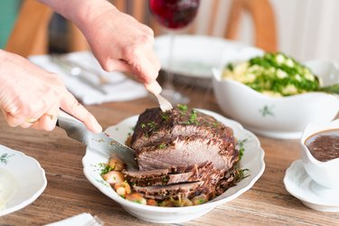 Woman cutting tender roast beef recipe