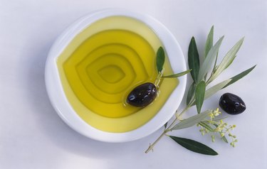 Bowl of olive oil, olives, twig of olive tree