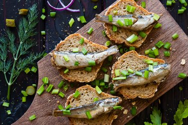 sandwich with sardines for bone health sprinkle with onions on a cutting board