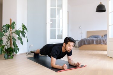 Asian man does planking exercise at home