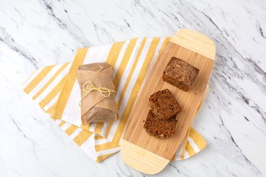 Homemade Zucchini Bread; One Loaf Sliced; Second Loaf Wrapped in Parchment Paper