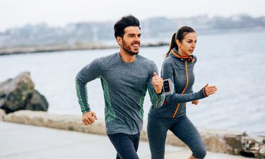 Friends running on a path by the sea to get the benefits of running