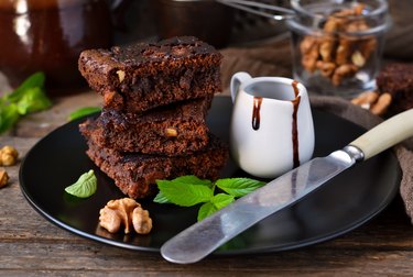 Homemade chocolate brownies with nuts, chocolate sauce and mint