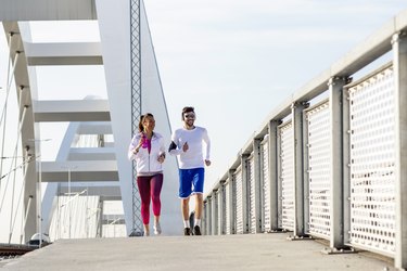 Couple jogging at the bridge with headphones