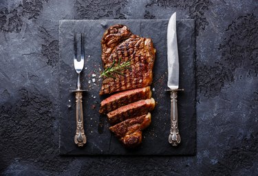 Sliced meat steak Striploin with knife and fork carving set