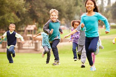 Group Of Young Children Running Towards Camera In Park