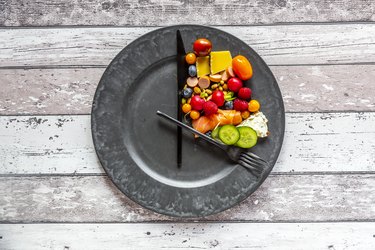 A variety of food in one corner of a plate, representing intermittent fasting