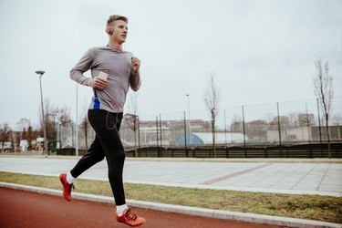 Young man running on tartan track