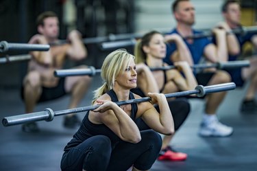 Woman performing weighted squats with a barbell