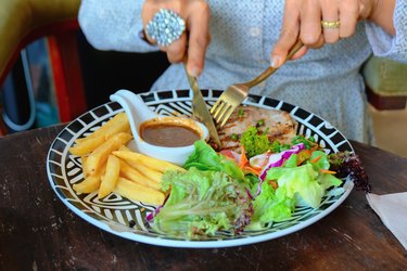 High Angle View Of Woman Eating Food On Table