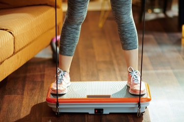 Closeup on sports woman training using vibration power plate