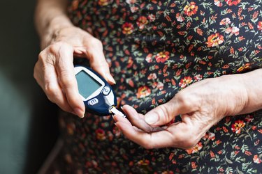 An older woman with type 2 diabetes checking her blood sugar