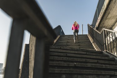 Young woman running up stairs