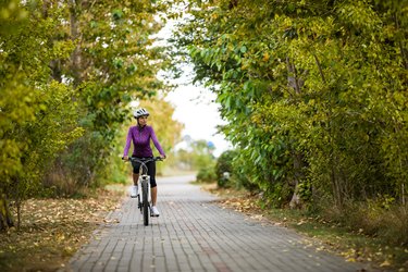 Urban biking - woman riding bike on cycle lane