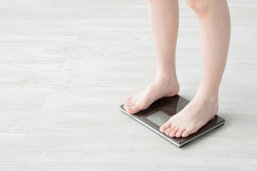 Woman getting on weight scale