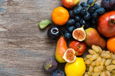 Juicy fresh fruit on a wooden dark table, top view.