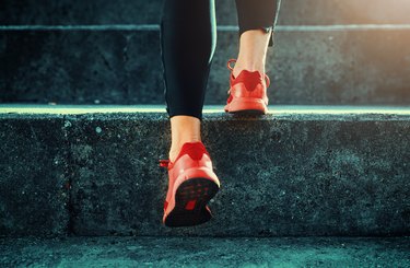 Close up shot of girl with chubby feet and fat toes in red running shoes walking up stairs