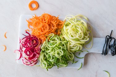 Spiralized Vegetables Noodle Carrot, Beetroot, Zucchini and Cucumber on Marble Board.