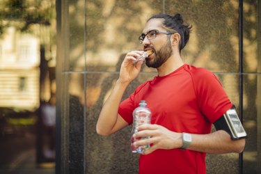 Runner having a snack during the middle of training for a marathon