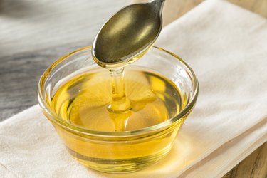 Raw Organic Sweet Light fructose-rich Agave Syrup being spooned out from a glass bowl from a silver spoon